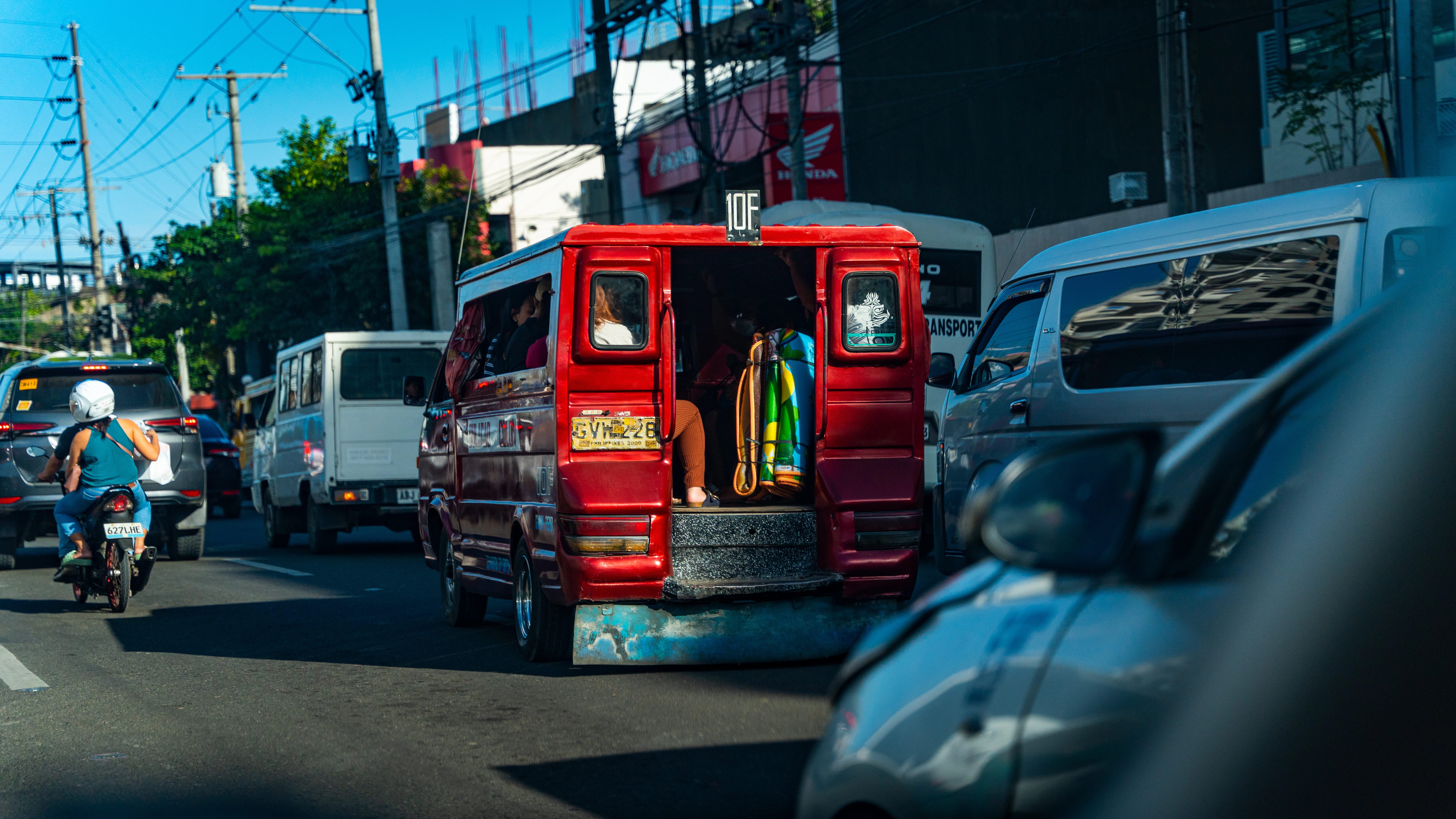 a man riding a bike down a street next to a red truck