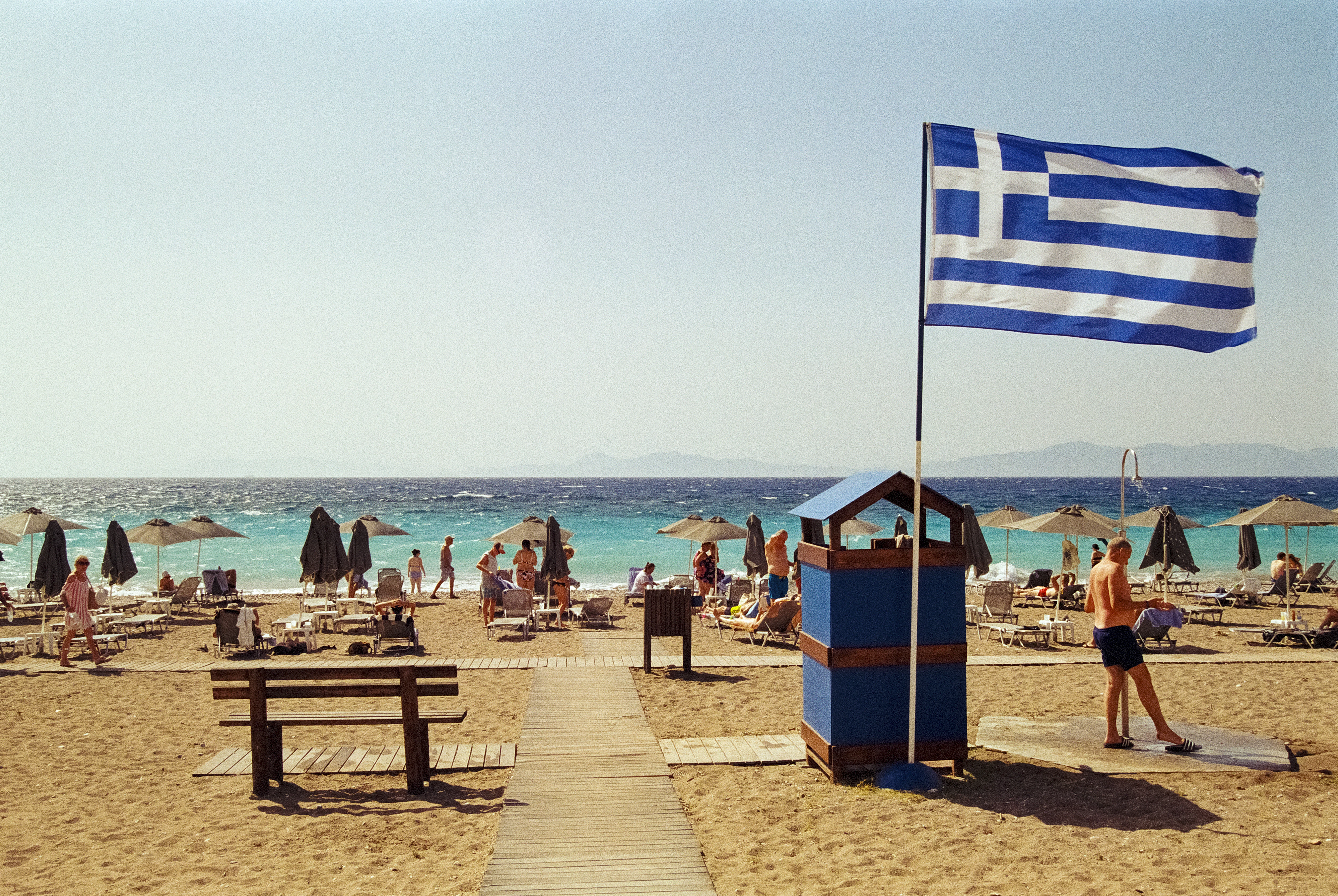A flag on a beach next to the ocean