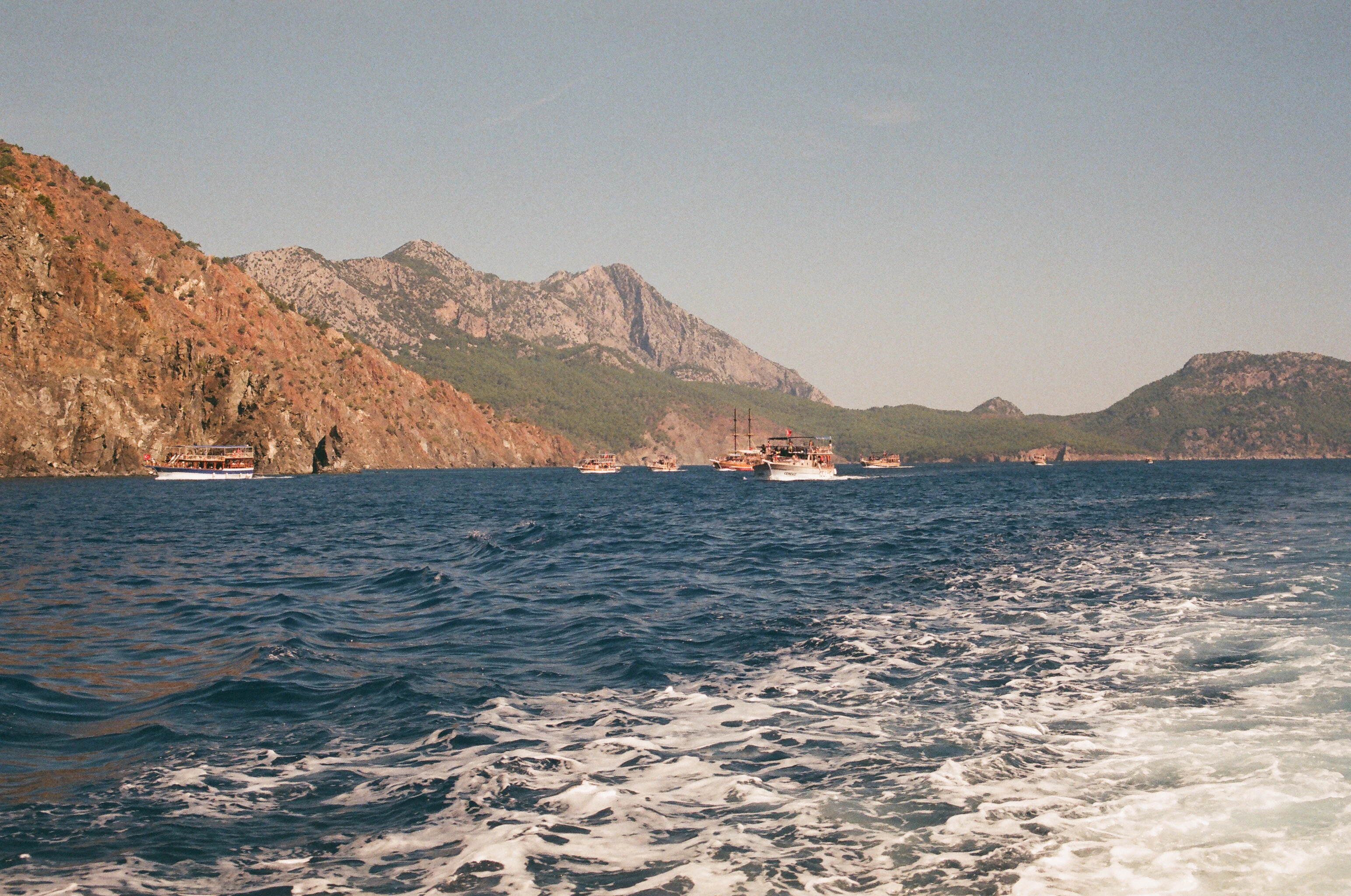 a boat traveling on a body of water near mountains