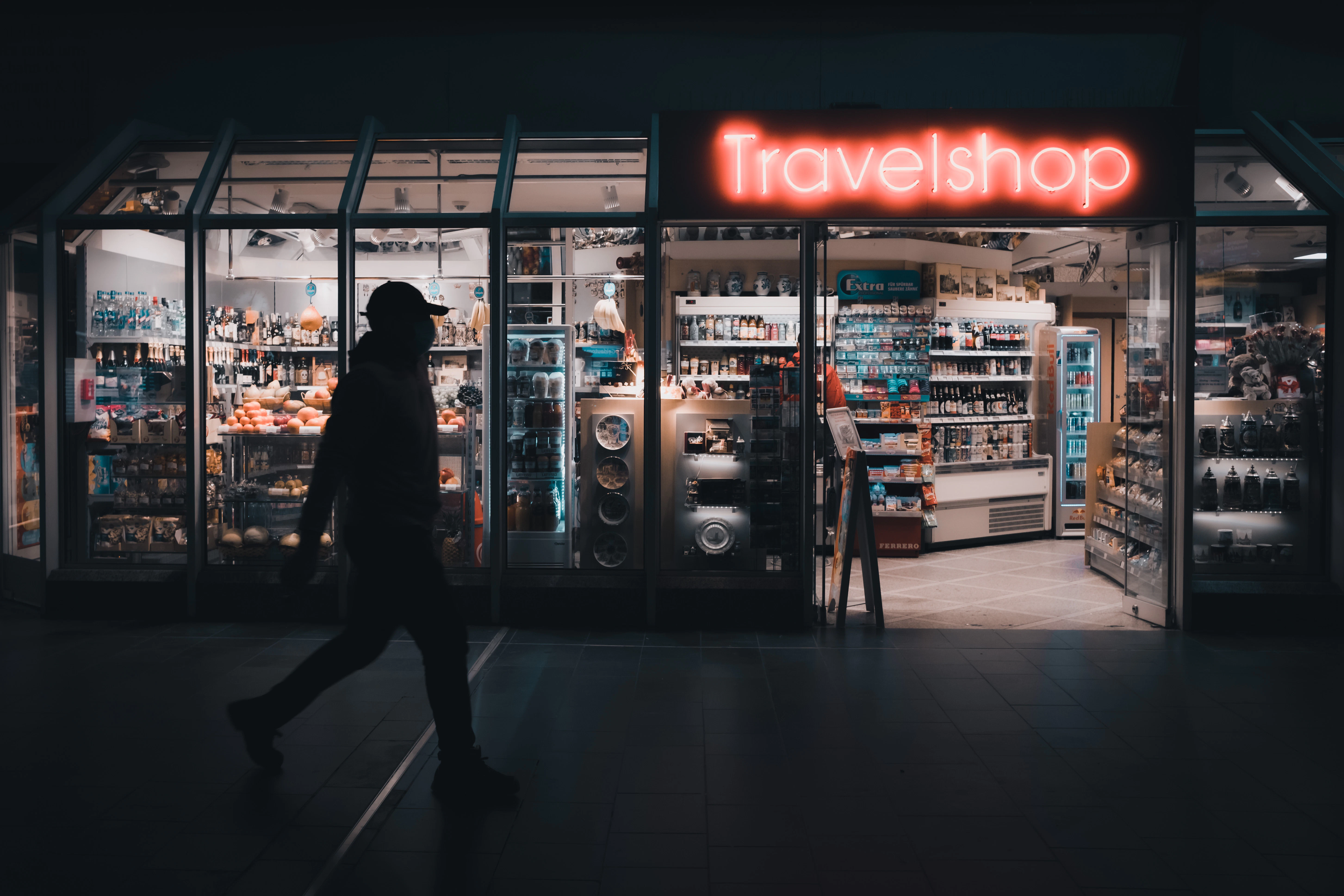 a person walking in front of a travel shop