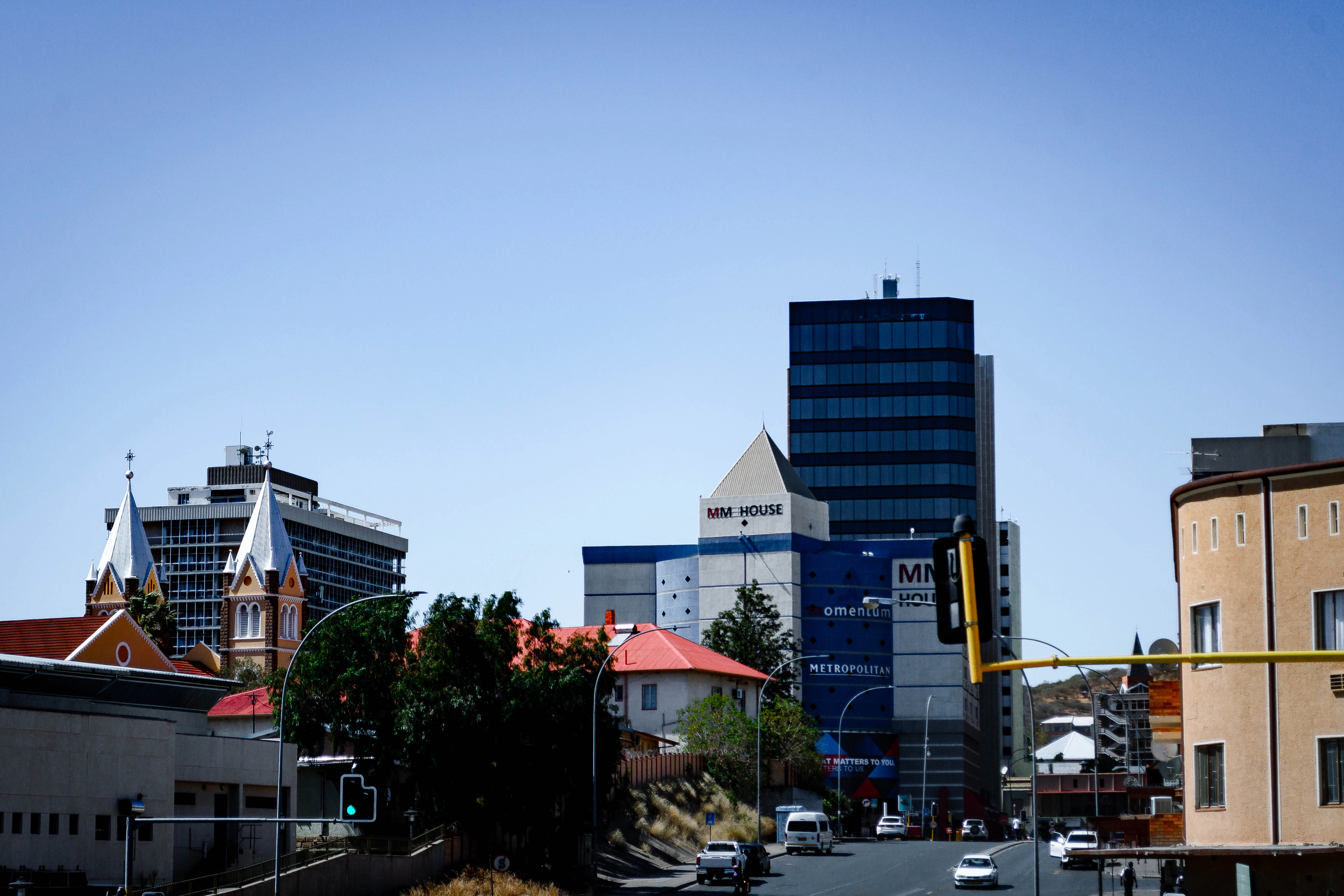 A city street filled with lots of traffic next to tall buildings