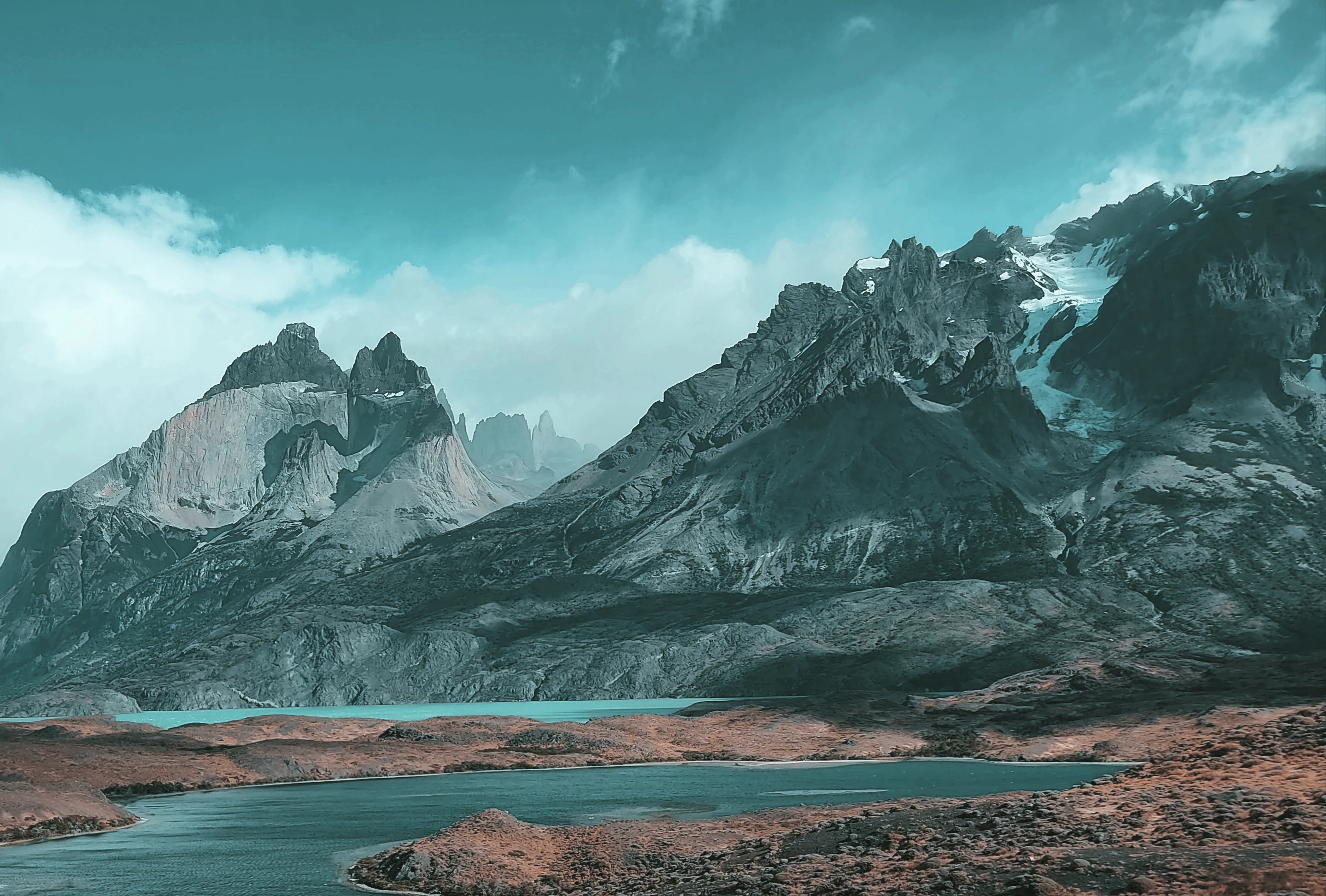 a body of water with mountains in the back
