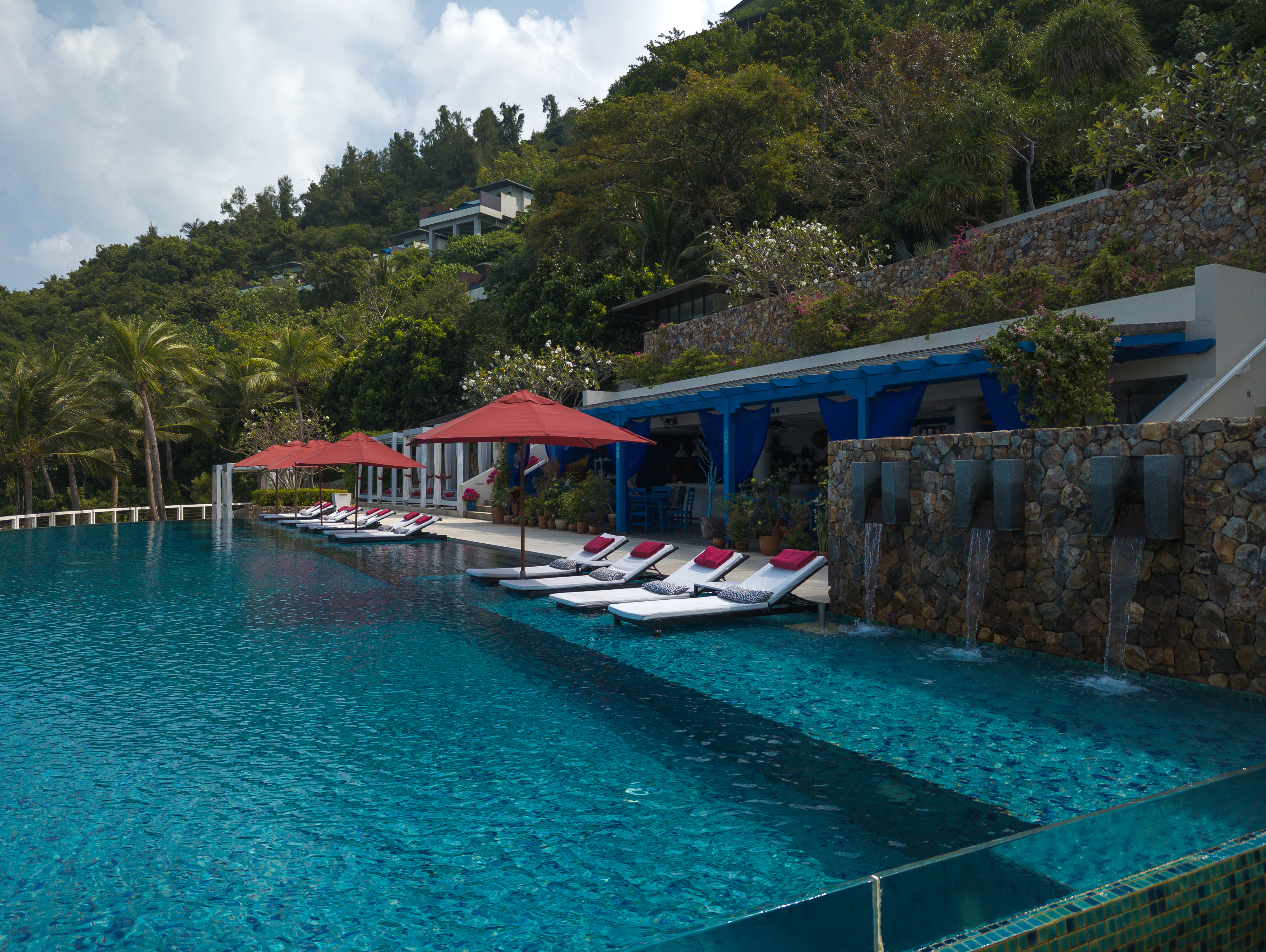 a row of lounge chairs sitting next to a swimming pool