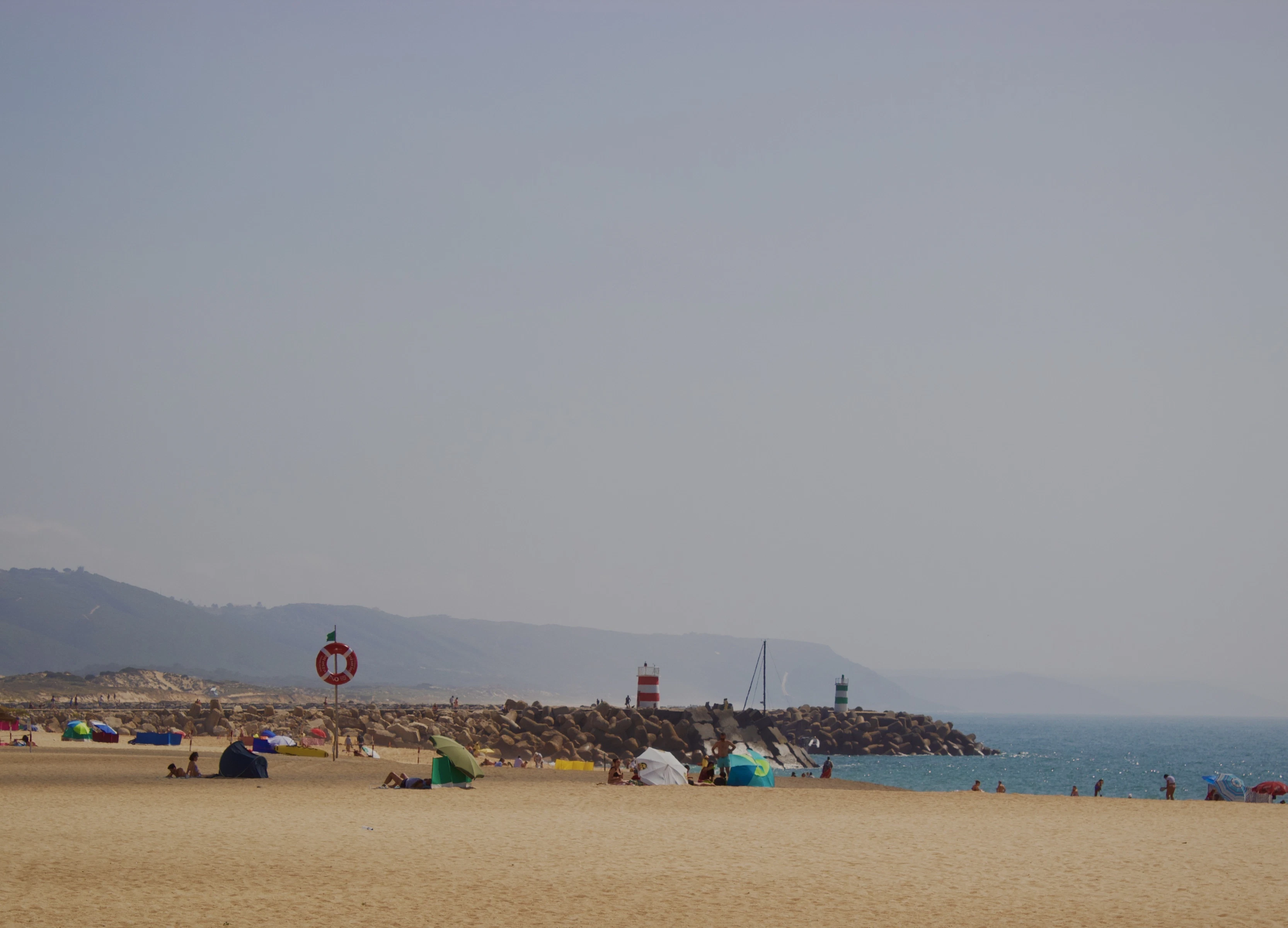 a group of people sitting on top of a sandy beach