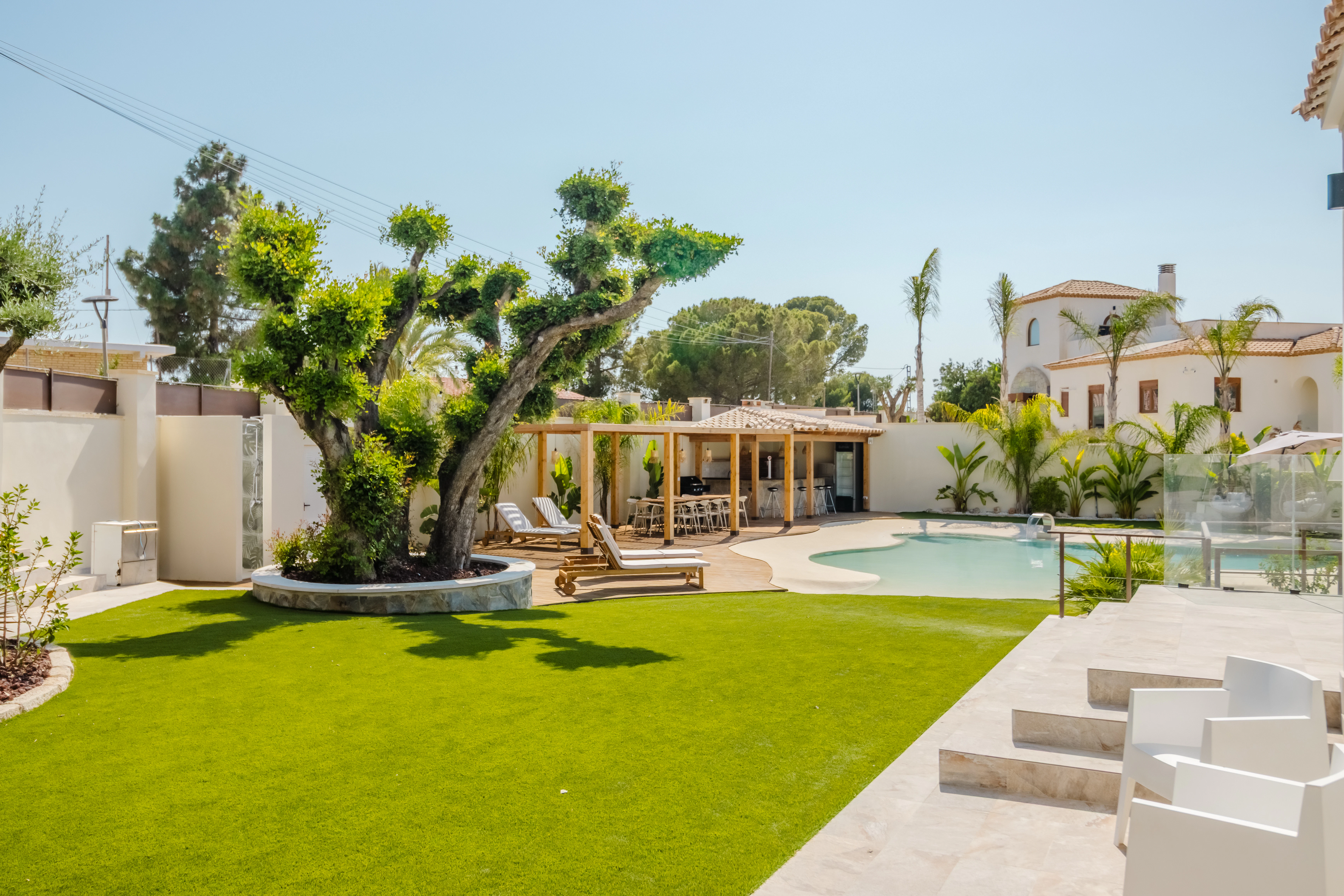 Luxurious backyard with pool, lounge chairs, and pergola.
