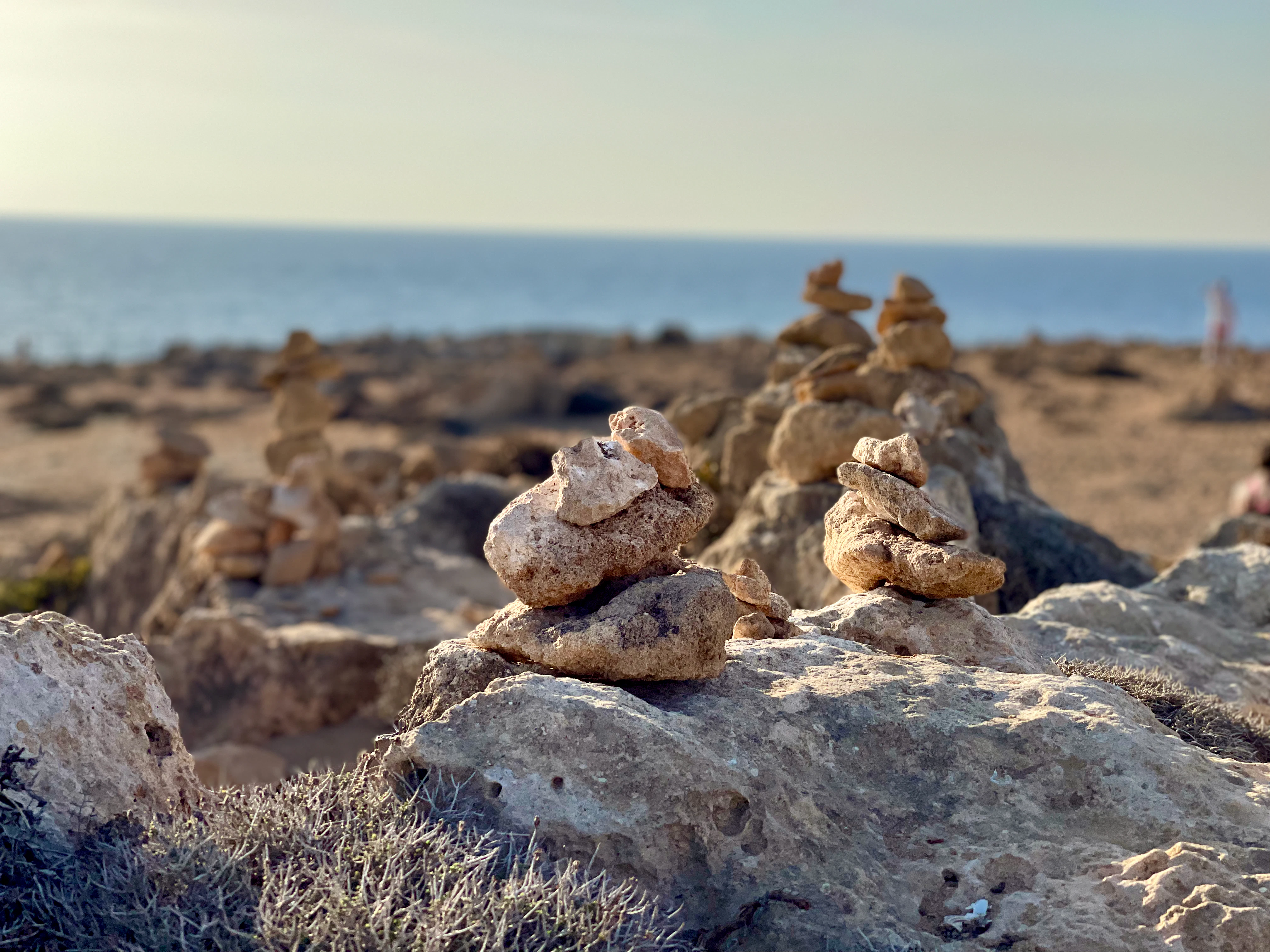 a pile of rocks sitting on top of a sandy beach