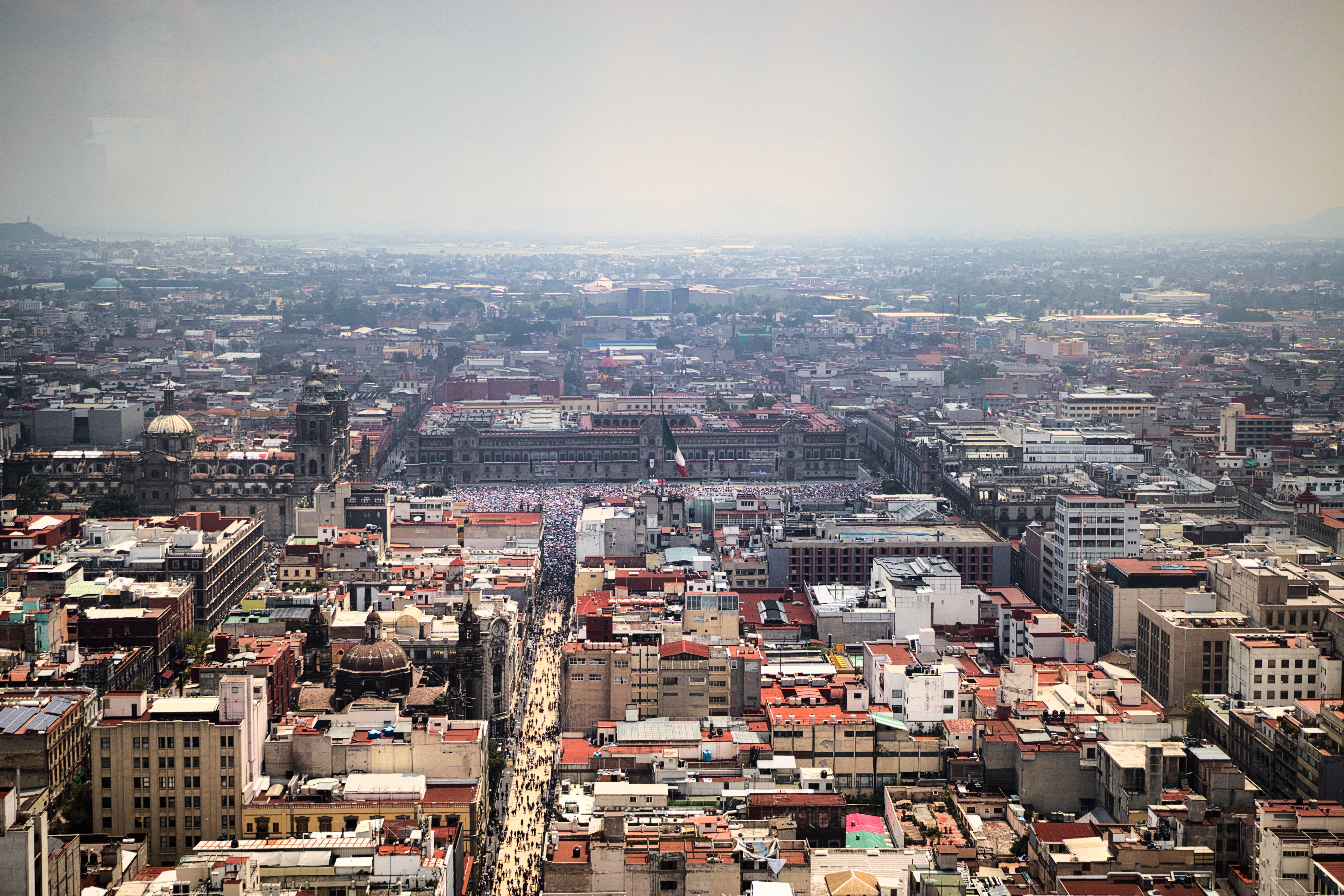 Expansive cityscape with buildings and distant mountains.