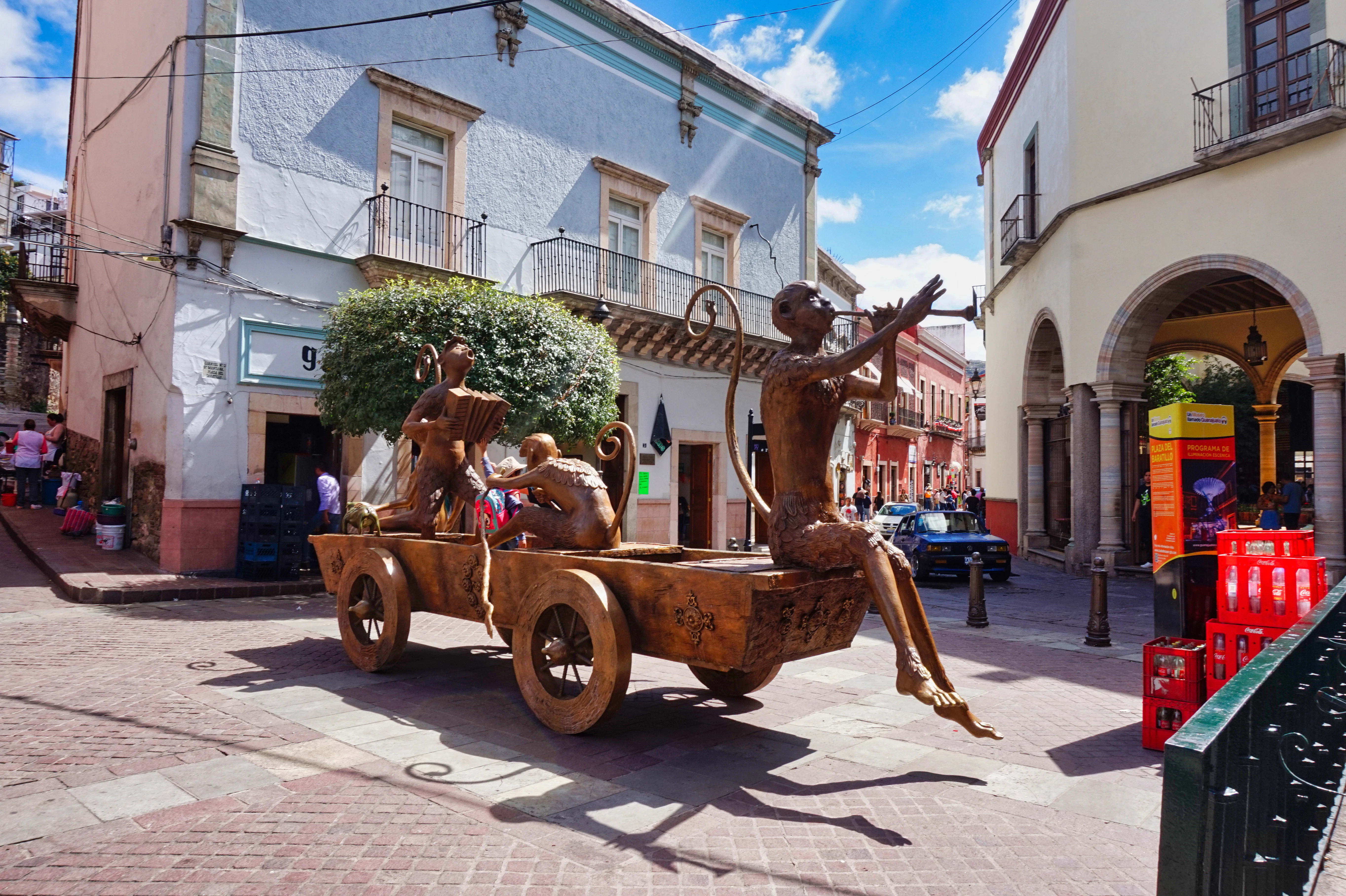 A statue of a man riding on the back of a wooden cart
