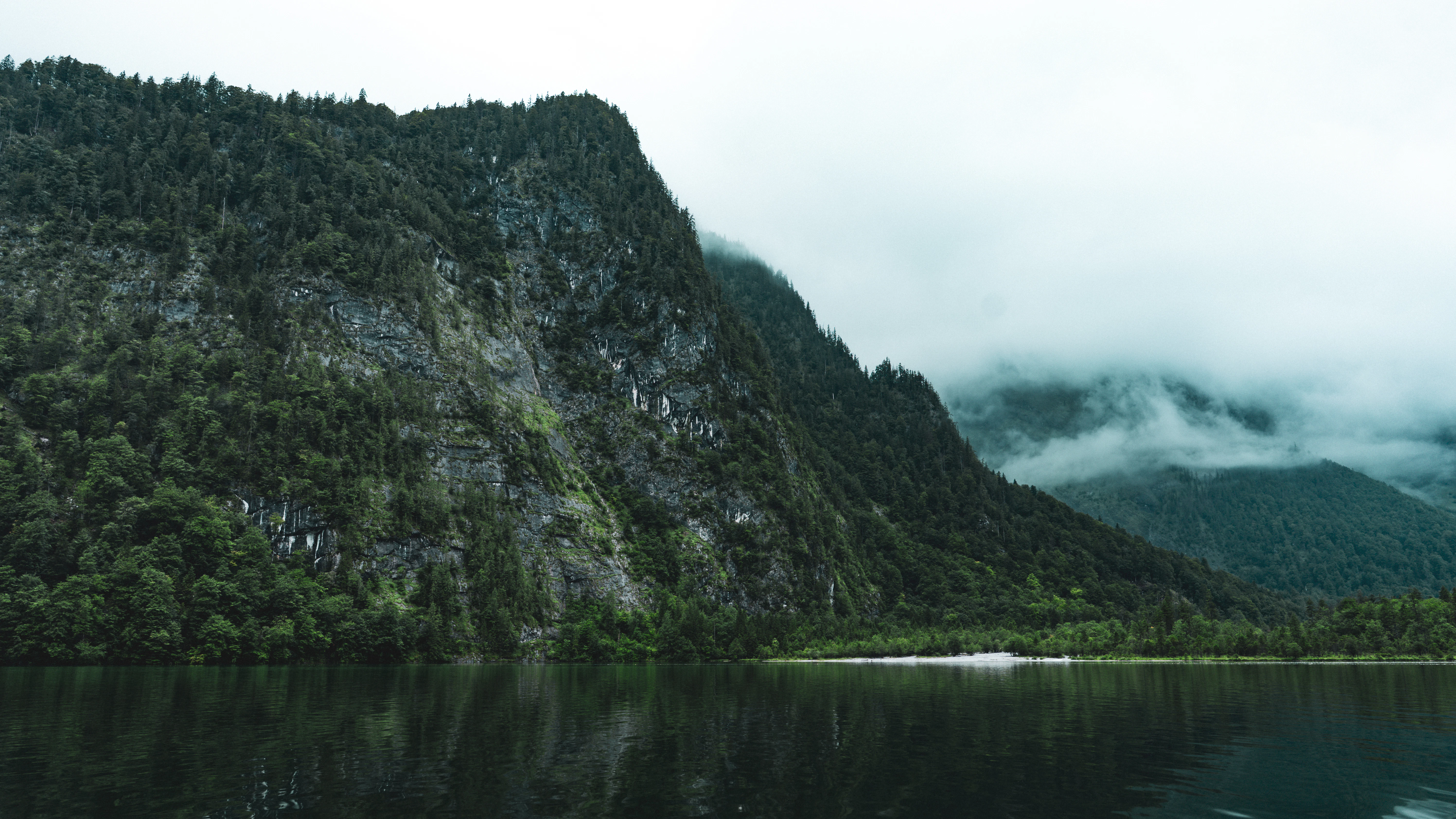 Mountains reflected in still, dark water.