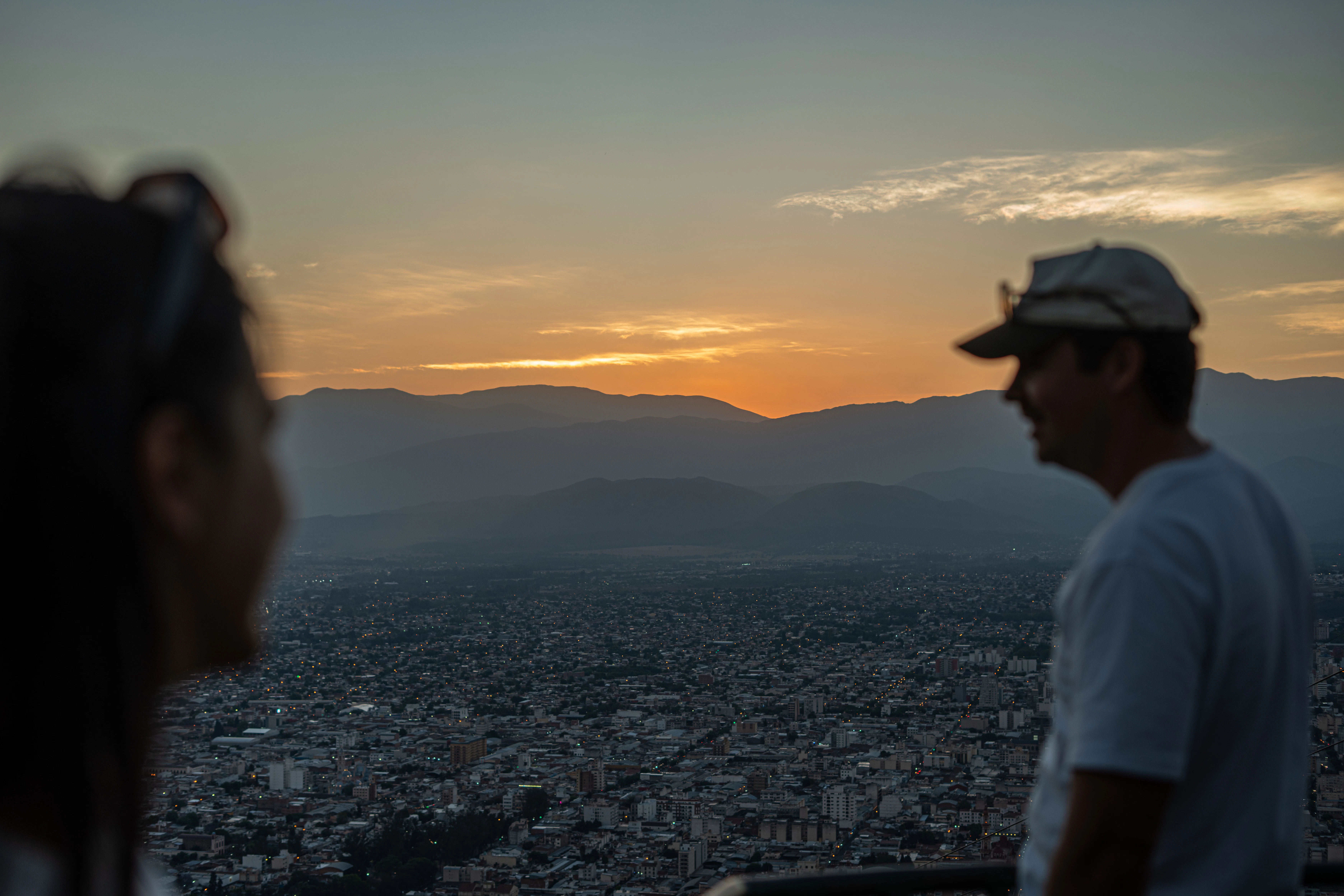Couple watching sunset over cityscape and city and mountains