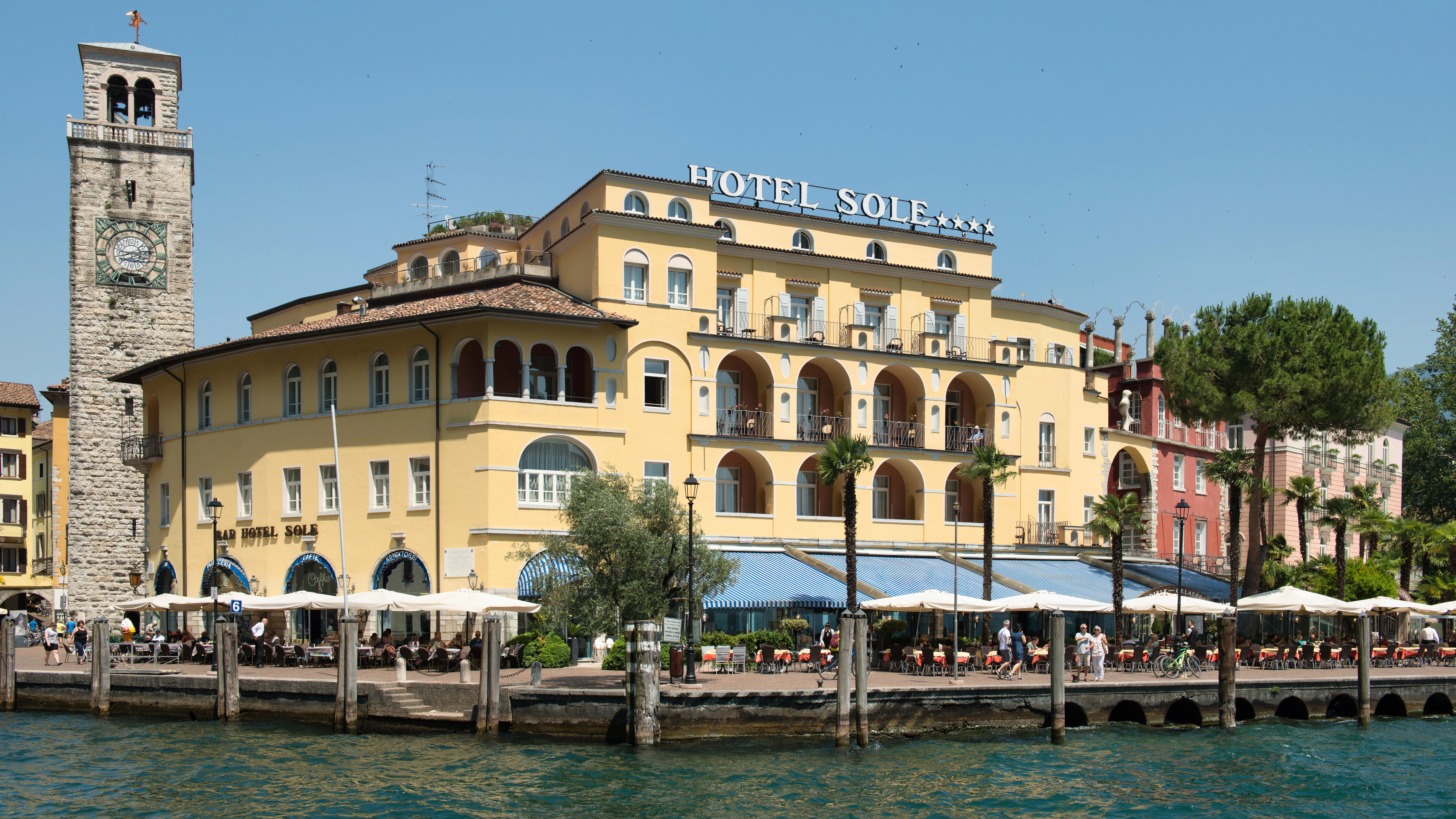 Yellow hotel building with clock tower by the water