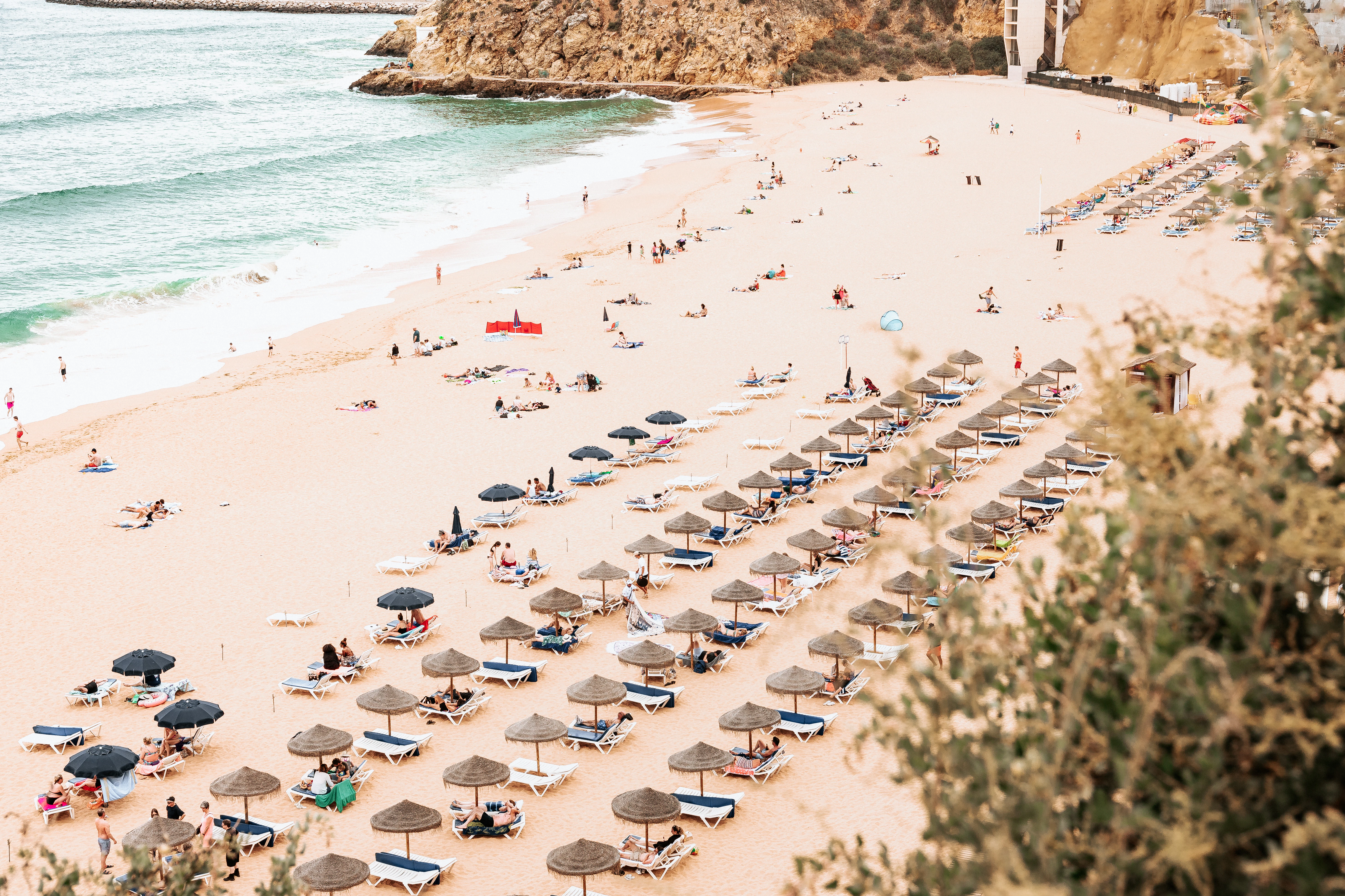 a beach with people and umbrellas
