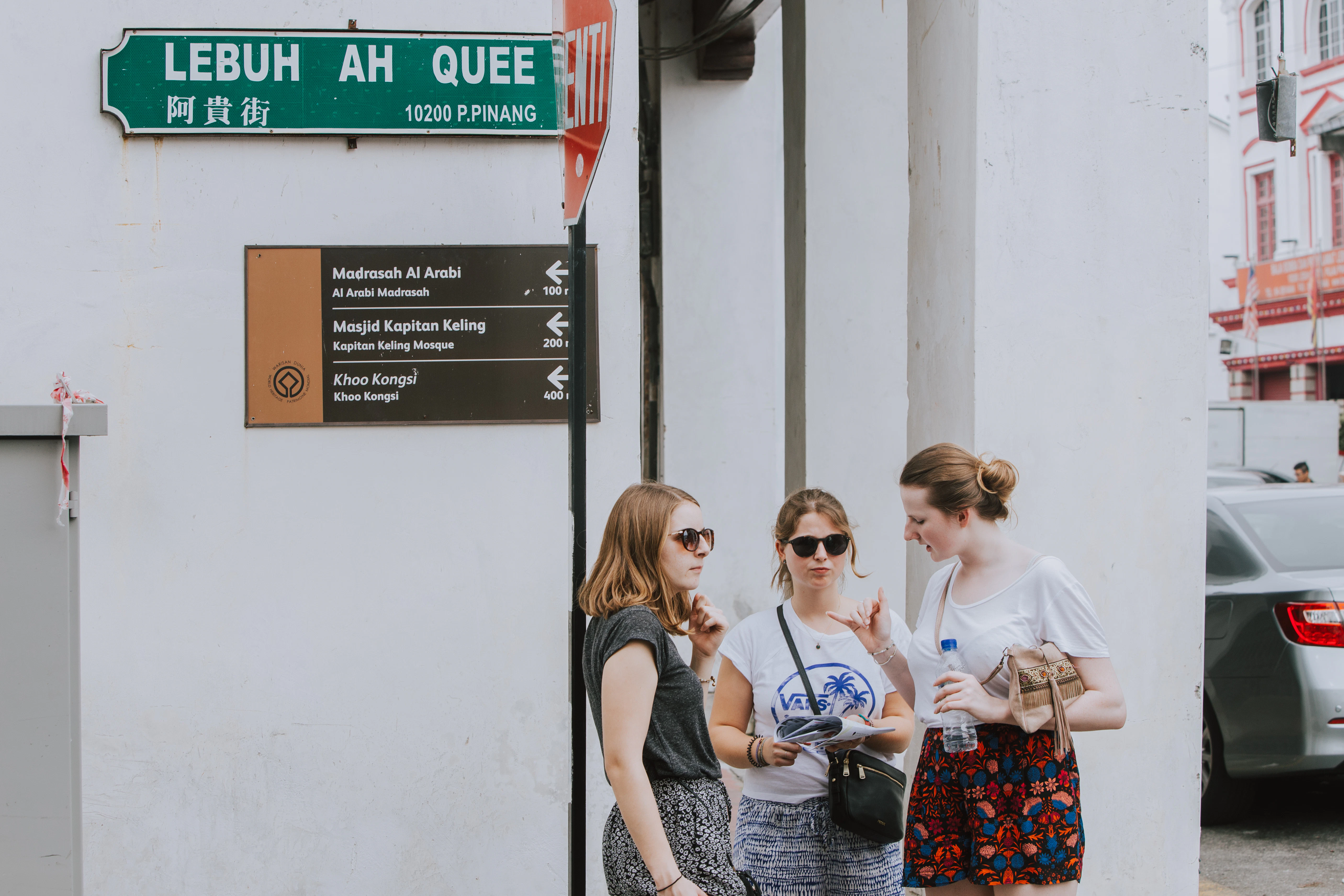 3 women standing beside white wall