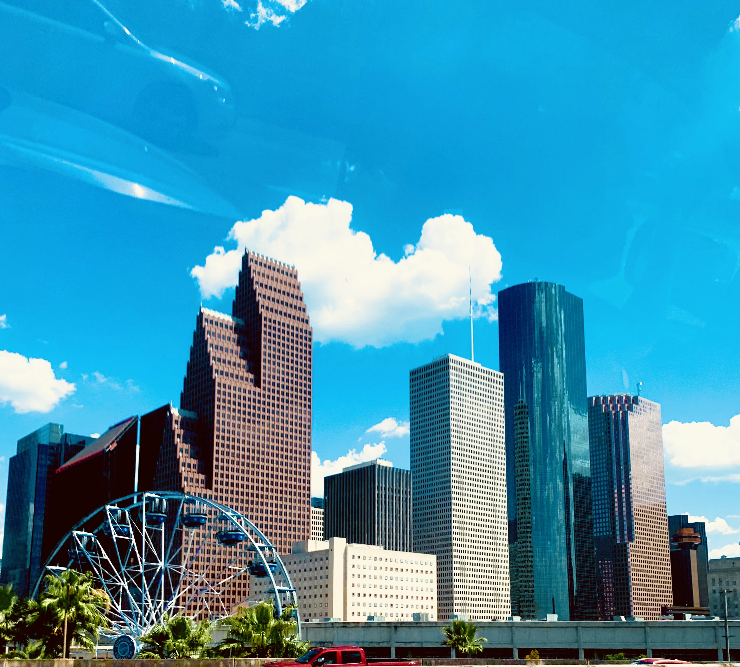 a city skyline with a ferris wheel in the foreground