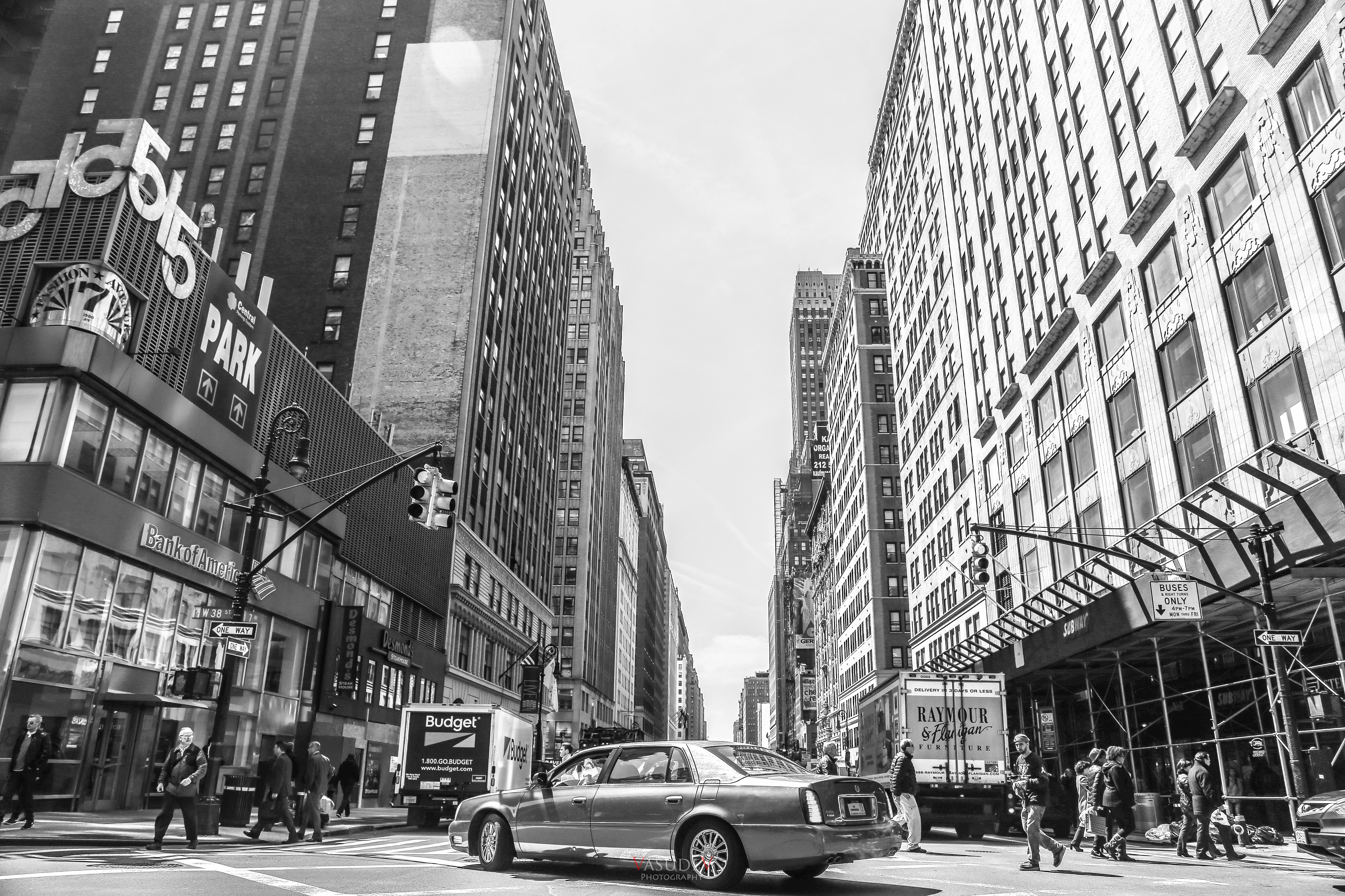 grayscale photo of cars on road near buildings