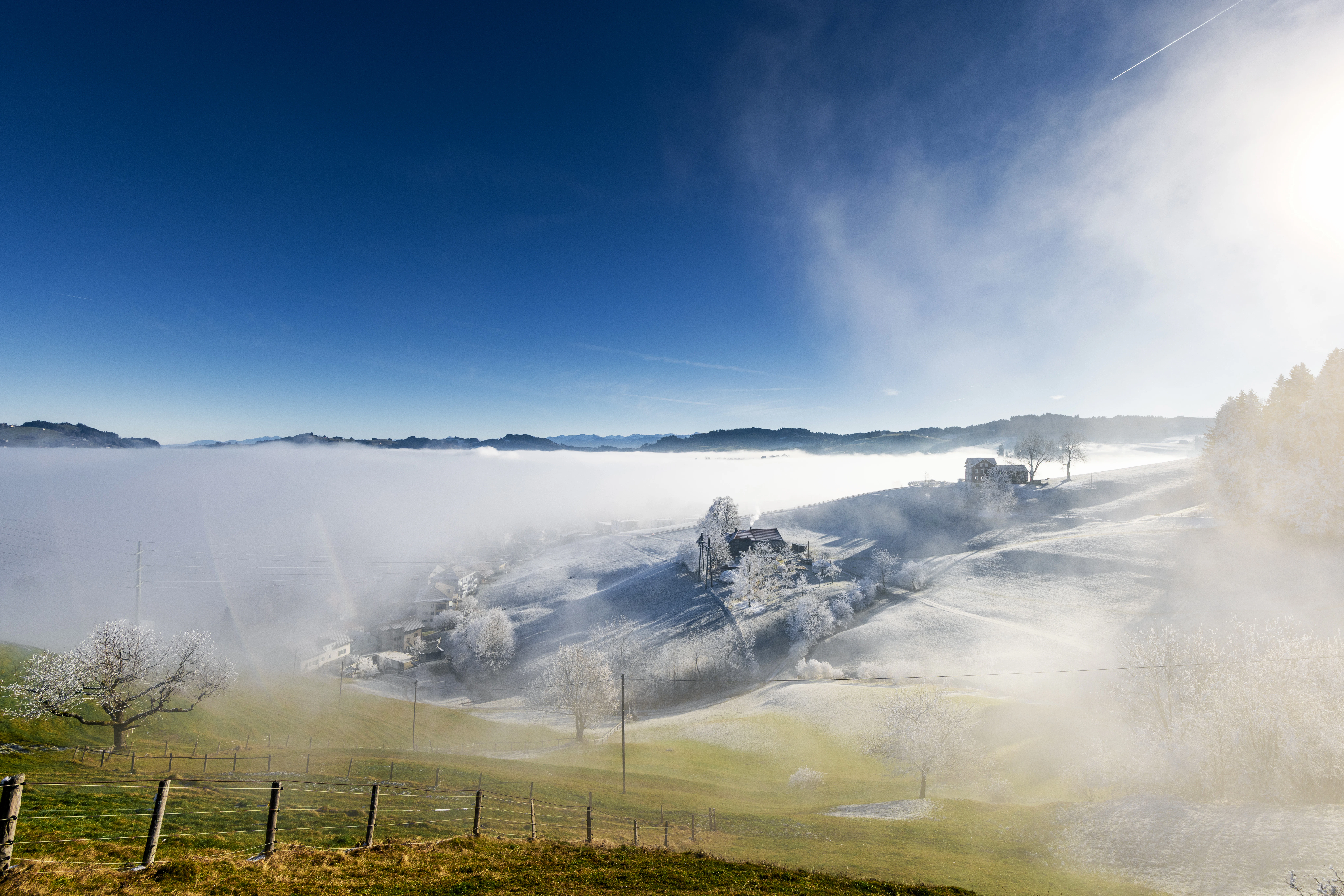 Misty hills with sunbeams and blue sky