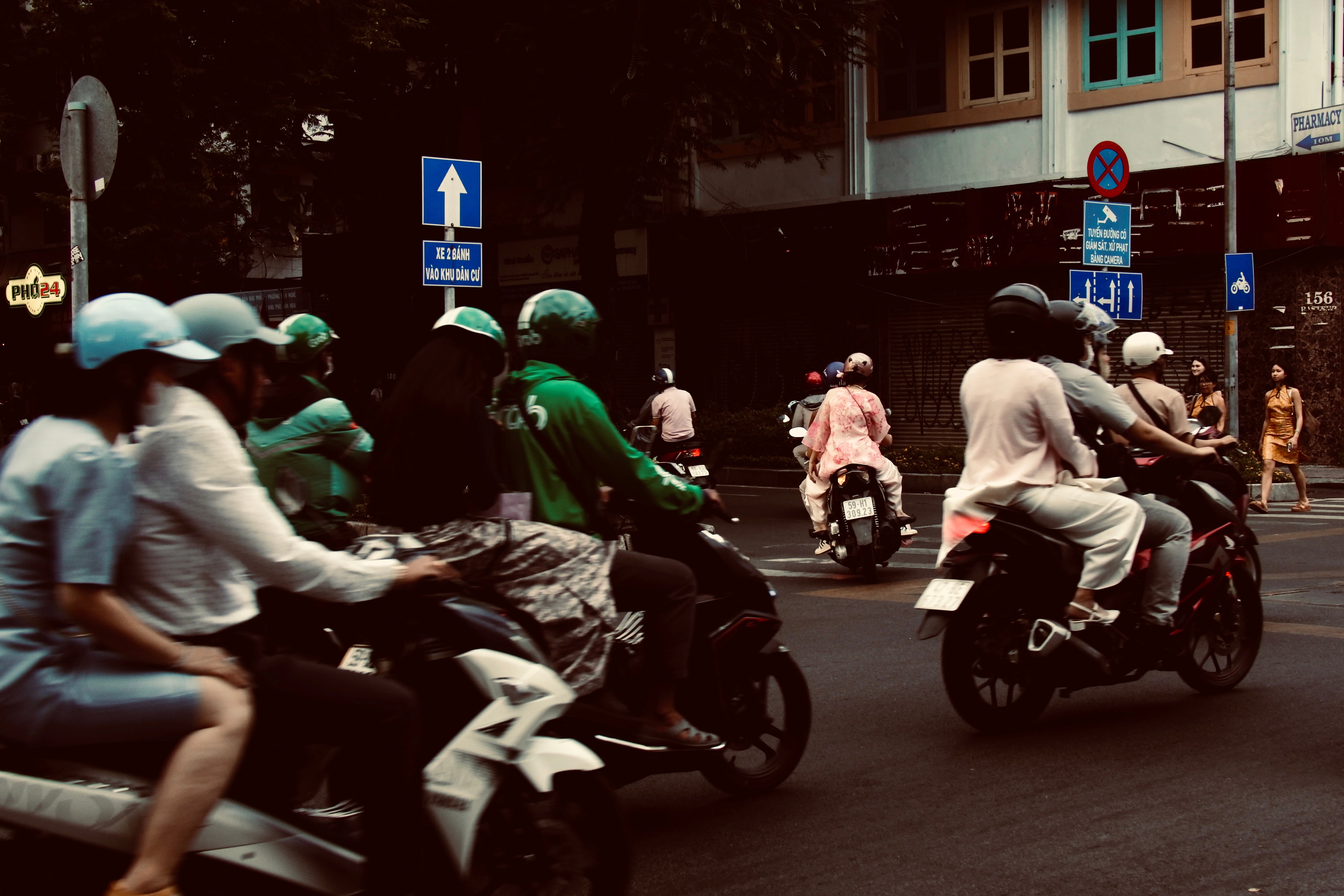 Motorcycles ride on a busy city street.