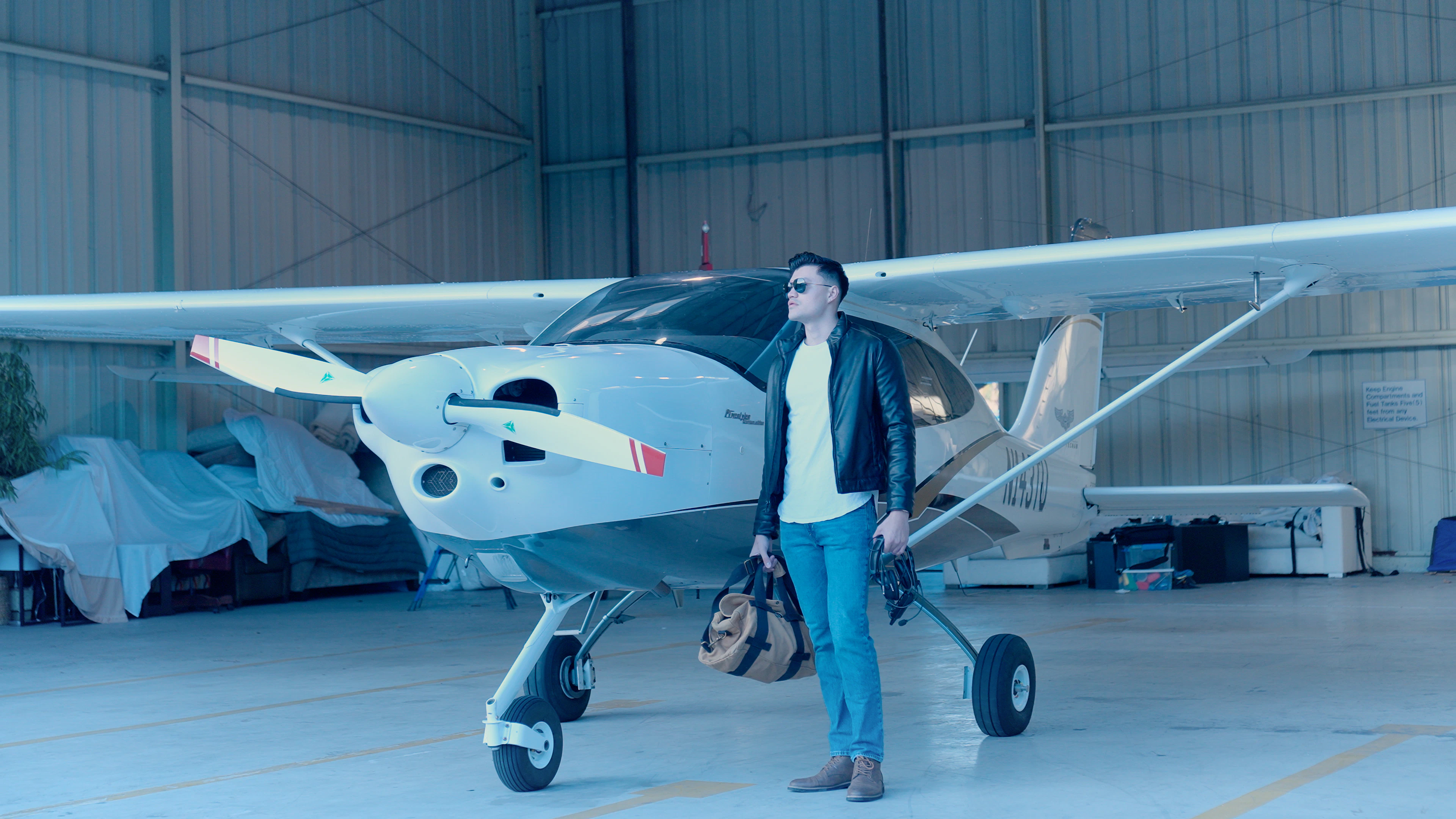 Man standing next to a small airplane in a hangar