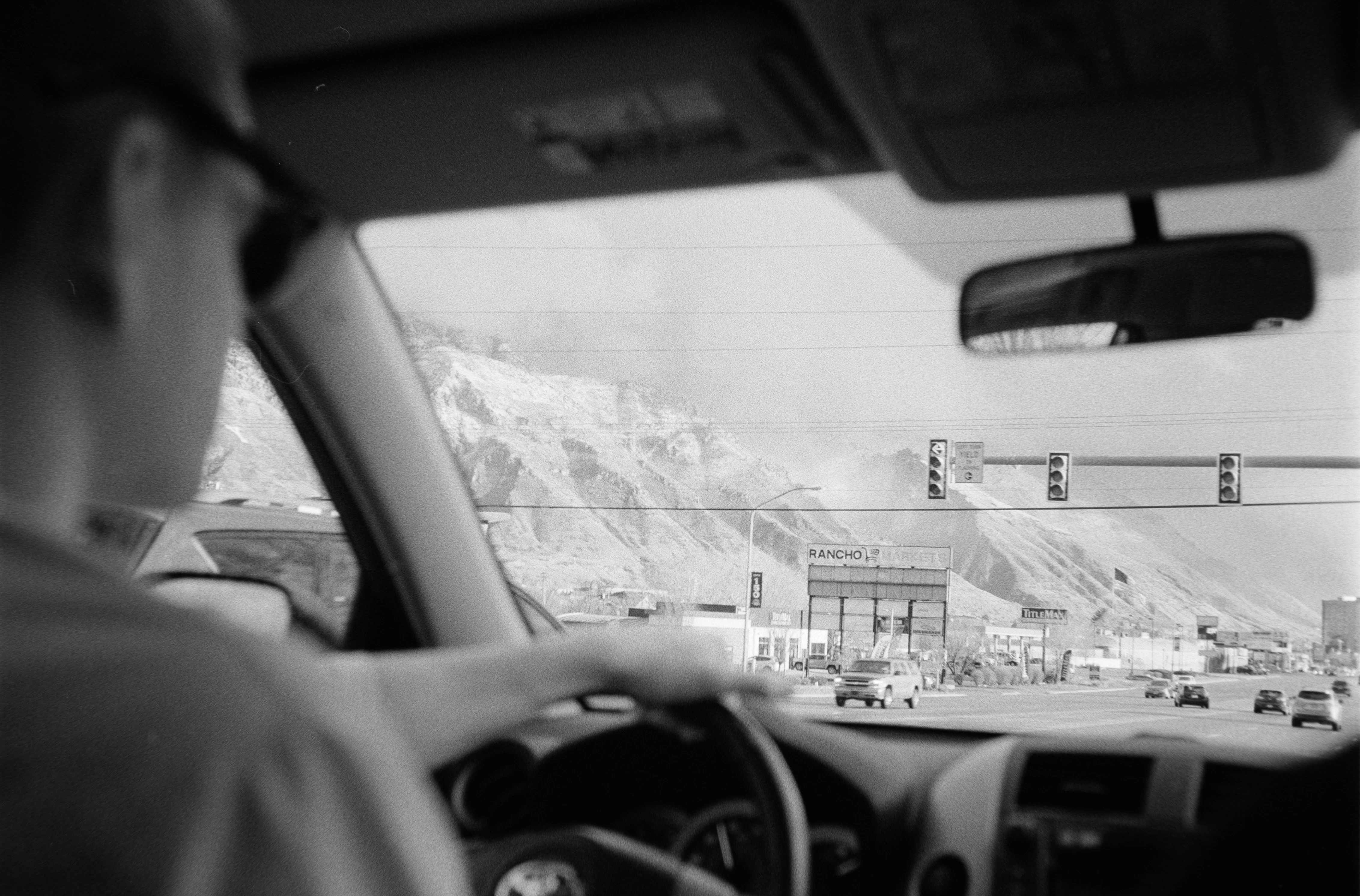 Person driving on a highway with mountains in background