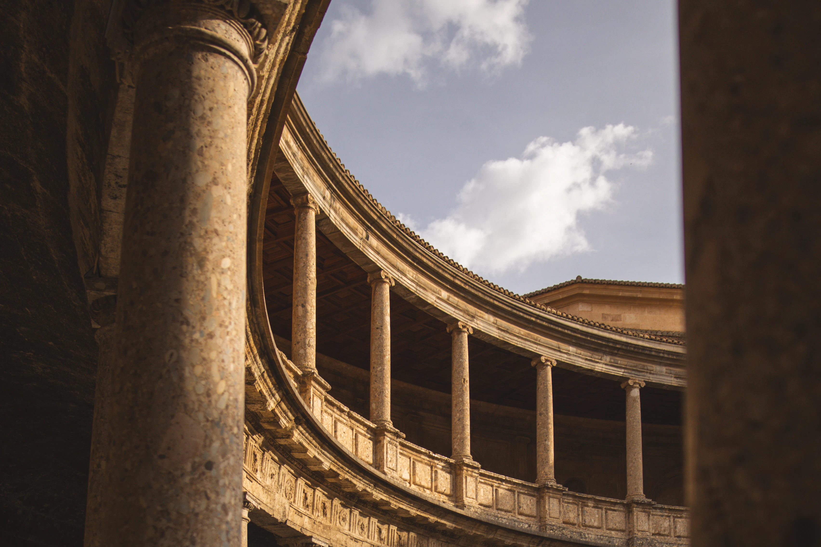 A circular building with columns and a sky background