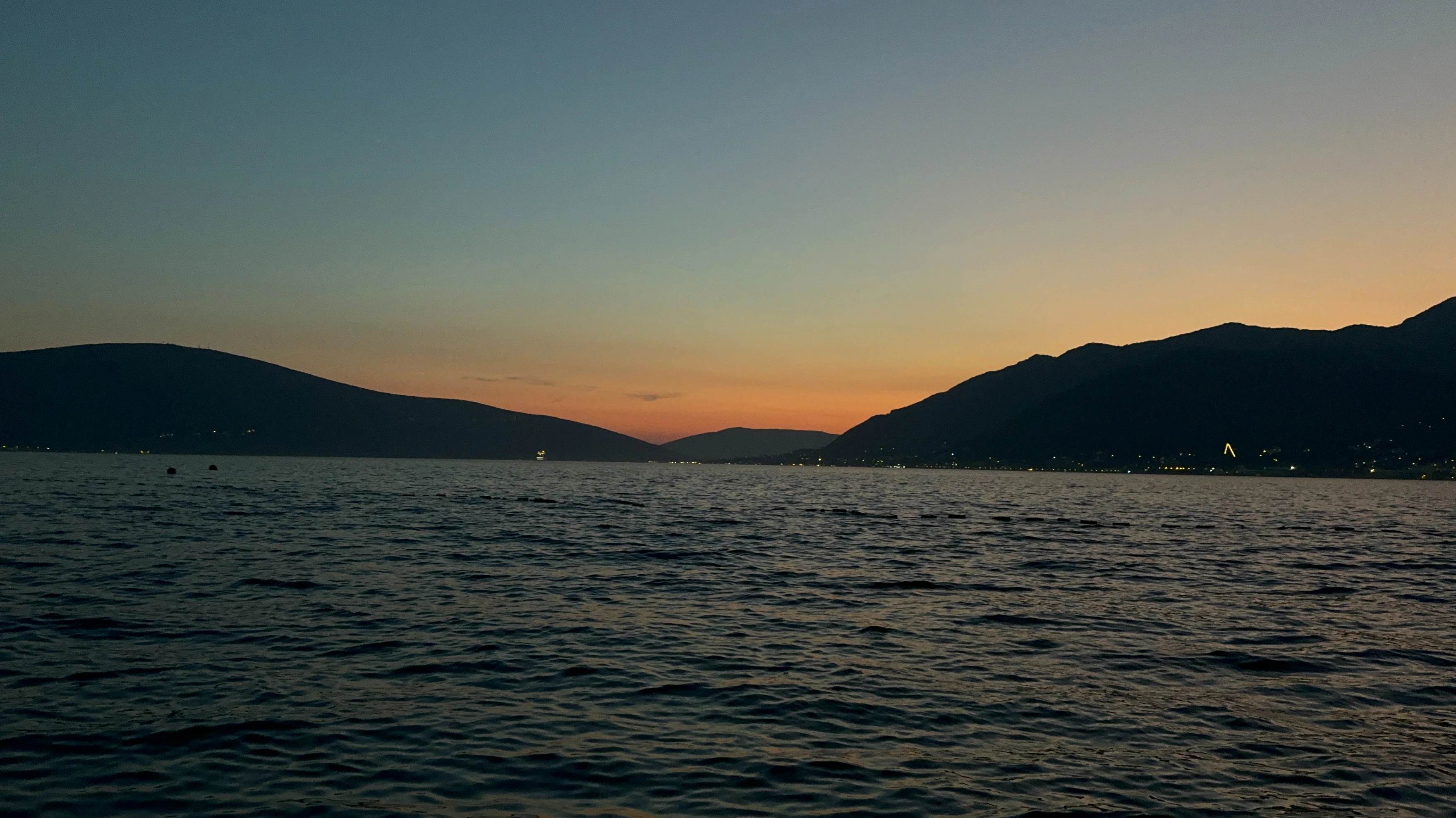 A body of water with mountains in the background