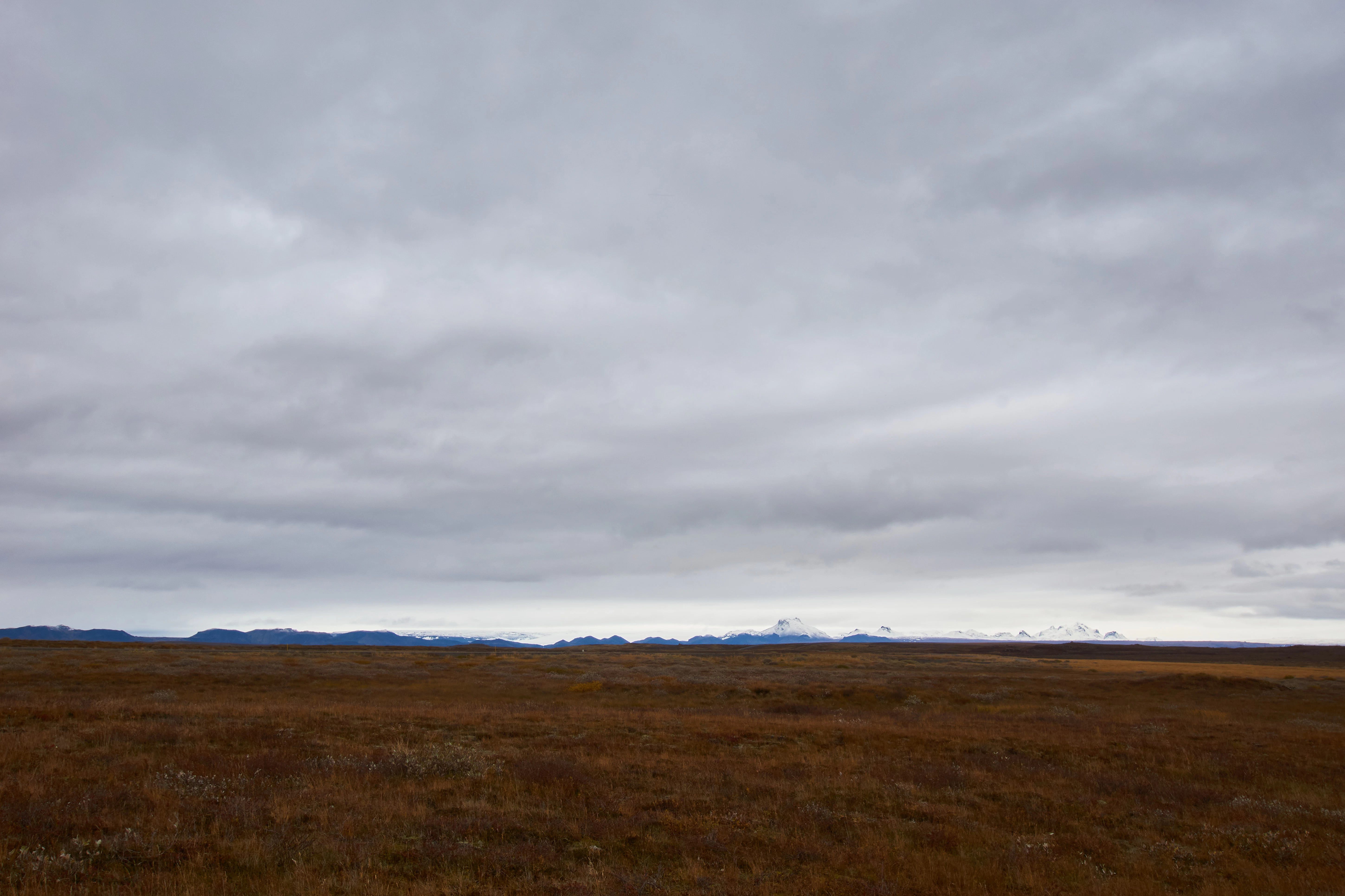 a large open field with mountains in the distance